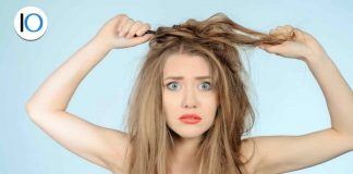 Donna su sfondo azzurro con capelli in disordine