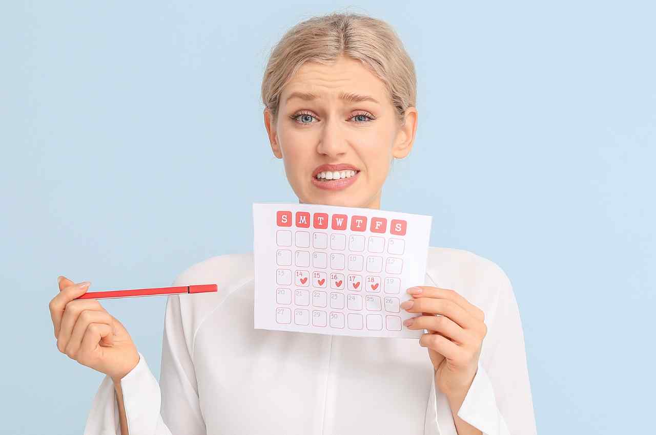 ragazza con faccia triste e calendario in mano