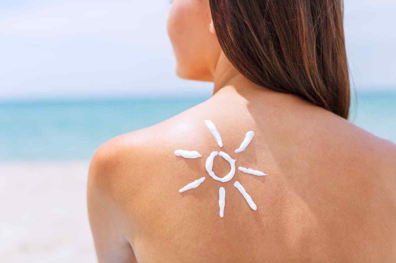 ragazza al mare con crema solare