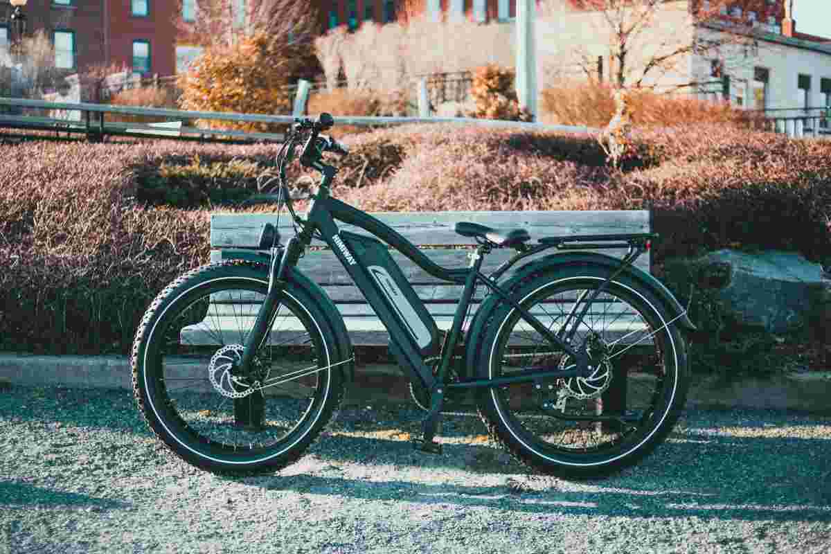 Bici elettrica appoggiata a una panchina in un parco