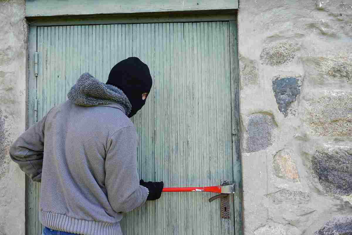 Un ladro mentre forza una serratura