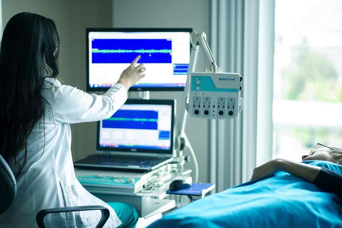 Operatore medico, paziente sul lettino e strumentazione elettronica