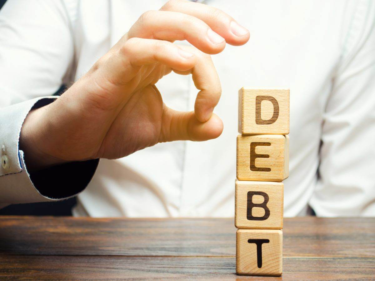 Uomo che cerca di far cadere dei dati con su scritto debit