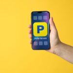 Mano con smartphone con app Poste Italiane