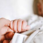 Neonato stringe la mano
