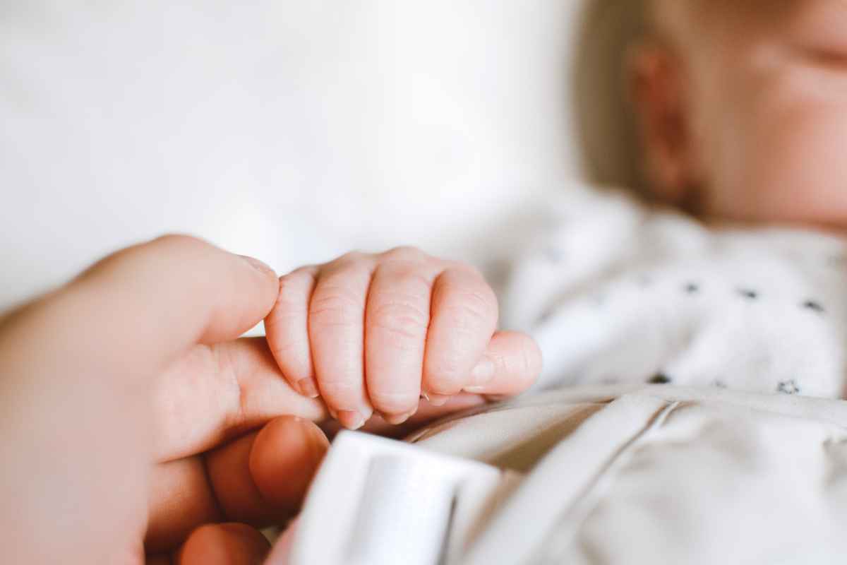 Neonato stringe la mano 