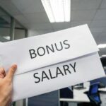 mano che sorregge biglietto con su scritto bonus salary