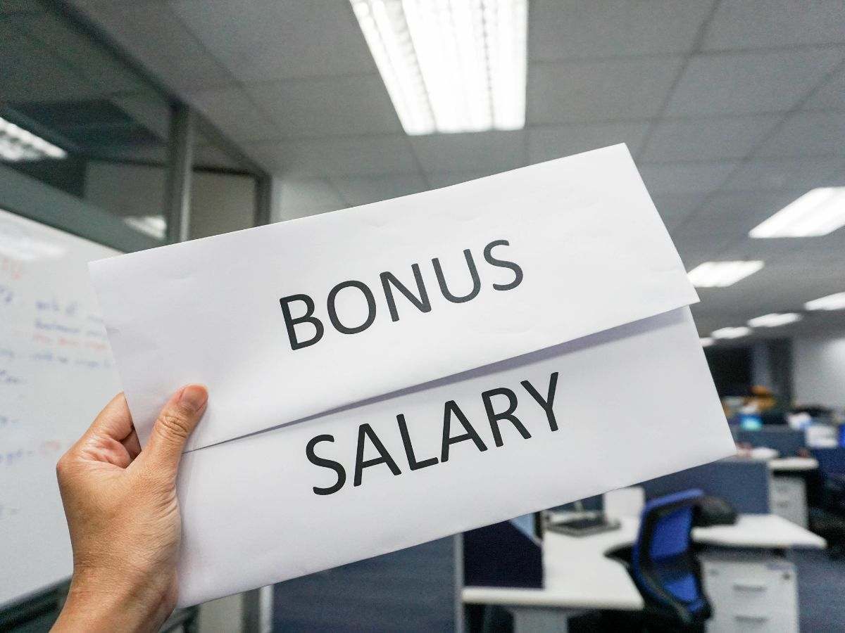 mano che sorregge biglietto con su scritto bonus salary