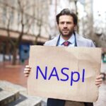 Uomo con cartellone in mano con su scritto NASpI