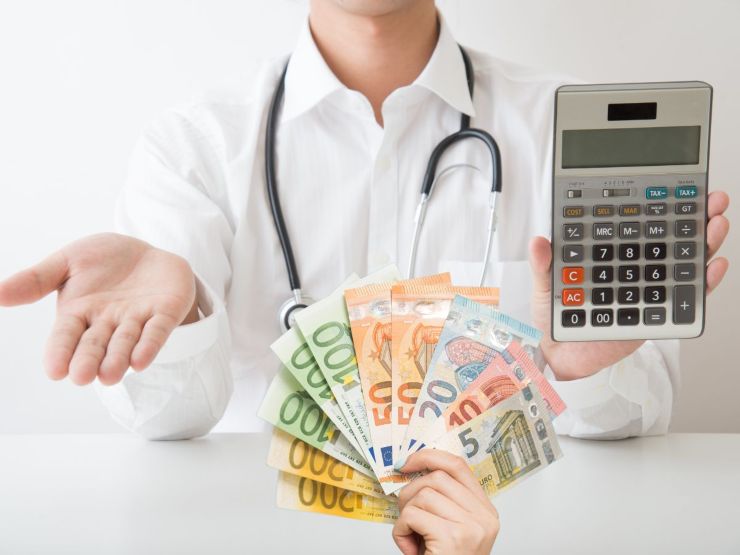 Medico con calcolatrice e mano con soldi