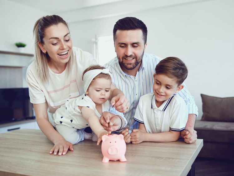 Famiglia con due figli piccoli con salvadanaio