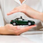 Mani che proteggono un modellino di auto