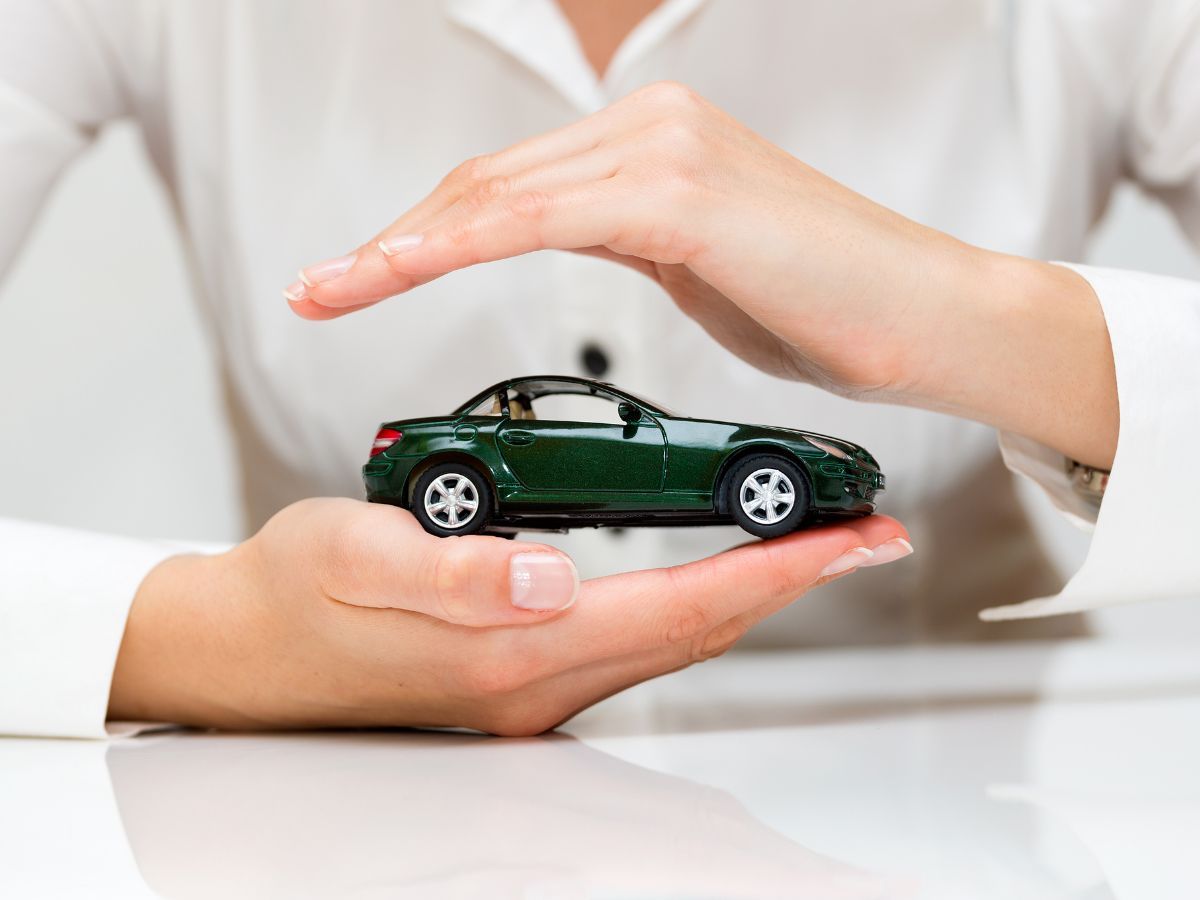 Mani che proteggono un modellino di auto