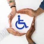 Mani intorno al simbolo di invalidità