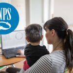Mamma con bambino in braccio davanti a un computer