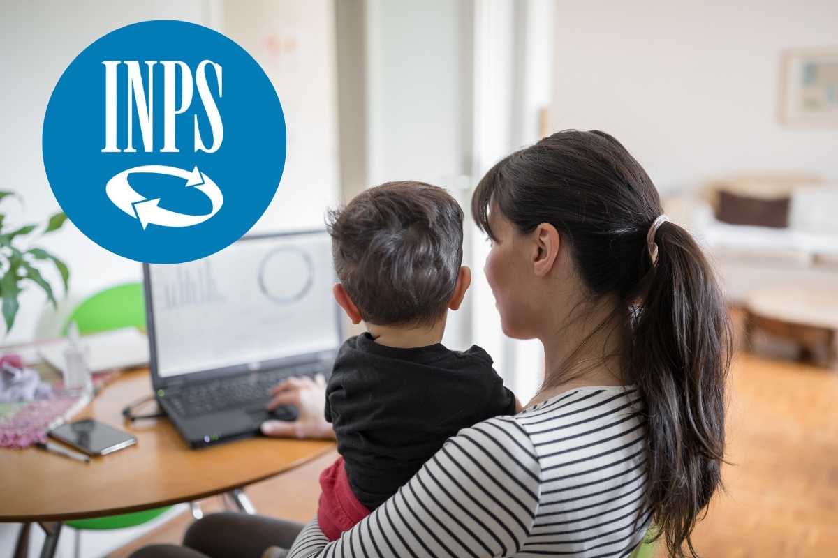 Mamma con bambino in braccio davanti a un computer