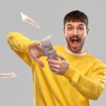 Uomo vestito in giallo che lancia soldi