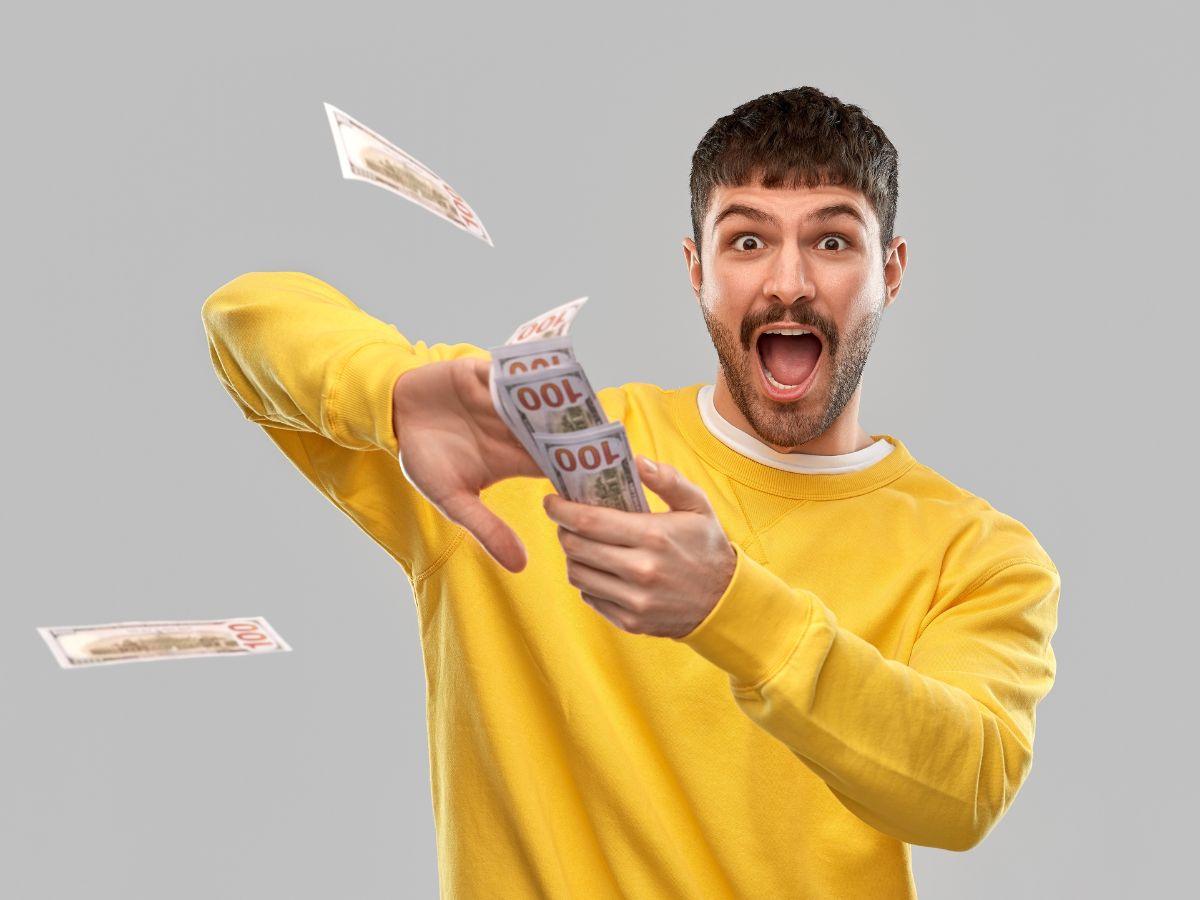 Uomo vestito in giallo che lancia soldi