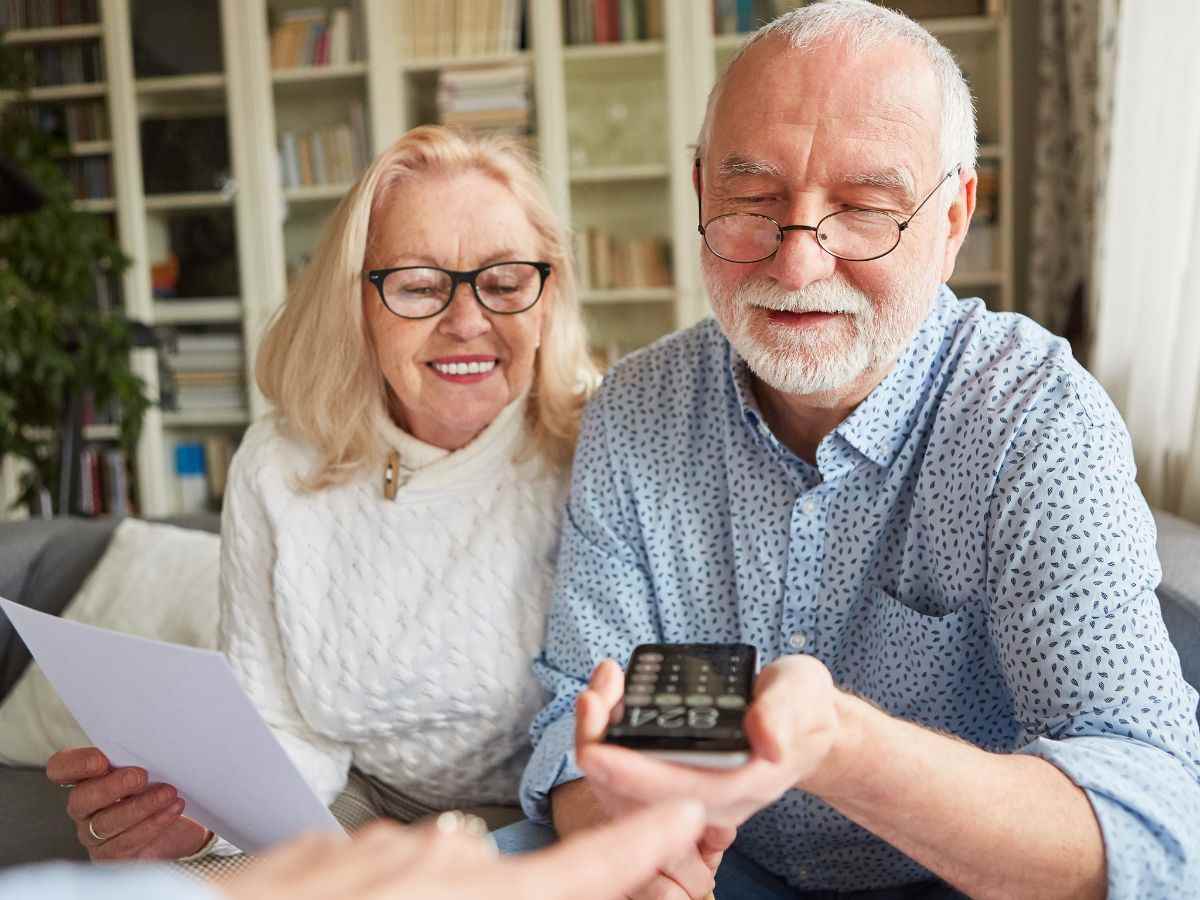 Coppia di pensionati con calcolatrice