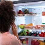 Donna davanti al frigorifero
