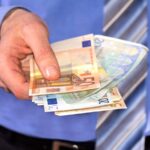 Uomo d'ufficio con soldi in euro in mano