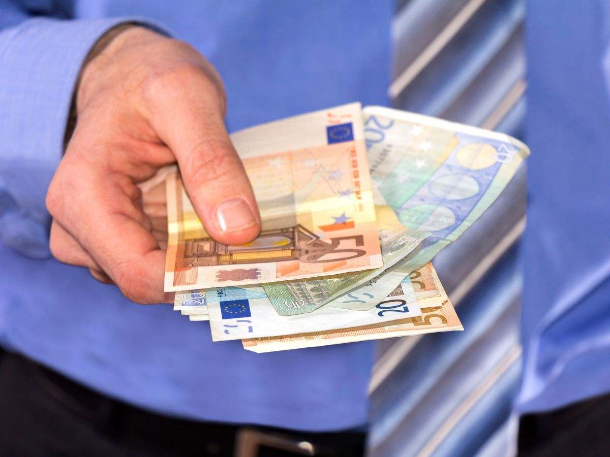 Uomo d'ufficio con soldi in euro in mano