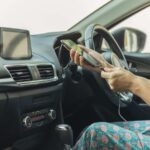donna che mette in carica il telefonino in auto