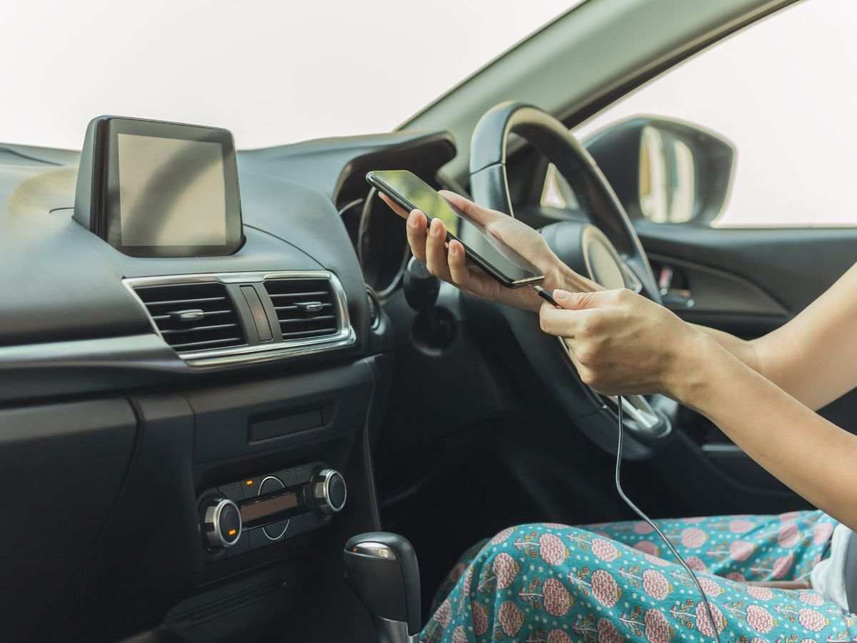 donna che mette in carica il telefonino in auto