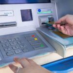 Bancomat e mani che inseriscono la scheda