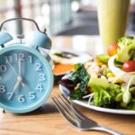 Sveglia e piatto di insalata con posate