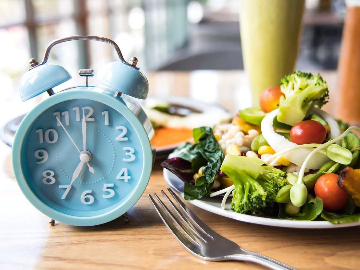 Sveglia e piatto di insalata con posate