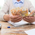 Mani anziane che contano i soldi
