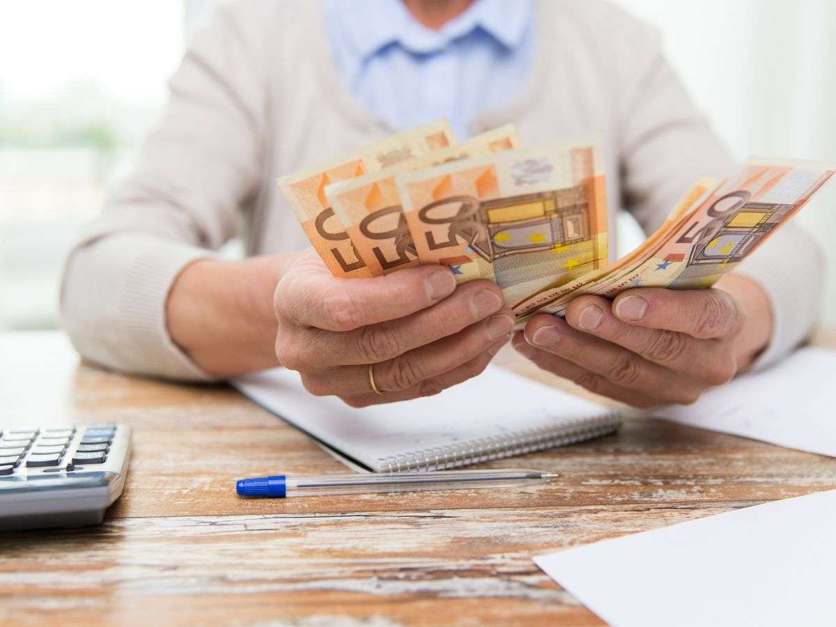 Mani anziane che contano i soldi