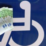 Foto con il simbolo invalidi e soldi in euro