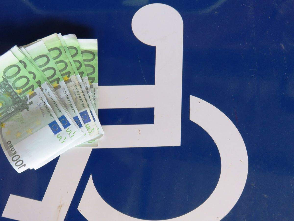 Foto con il simbolo invalidi e soldi in euro