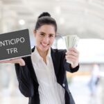 Donna con pc in mano dove è scritto "anticipo TFR" e nell'altra mano i soldi