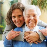 Donna che abbraccia una signora anziana