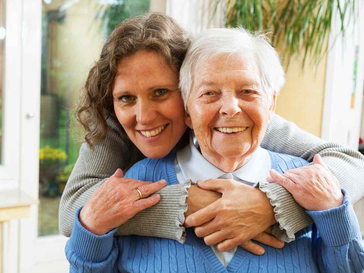 Donna che abbraccia una signora anziana