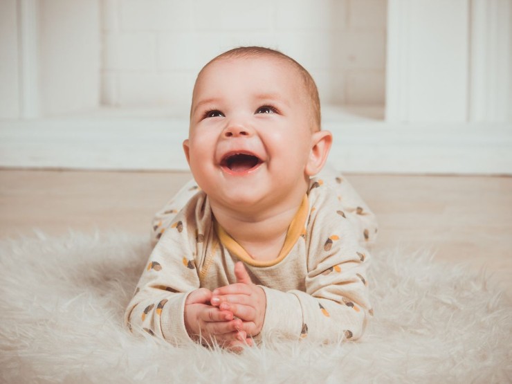 Neonato sul letto sorridente
