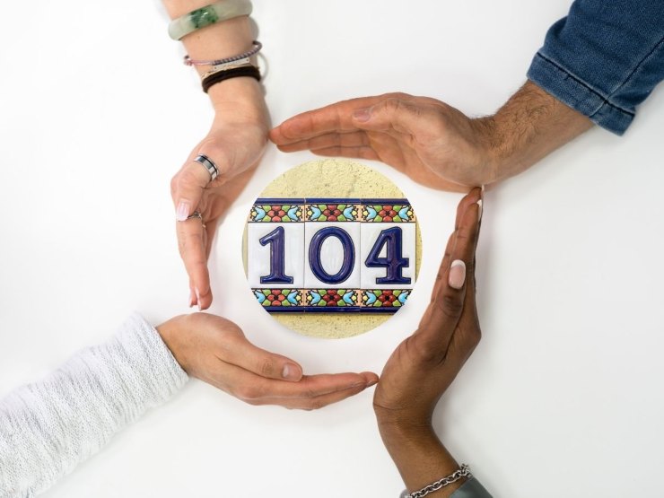 Mani chiuse a cerchio con dentro il numero 104