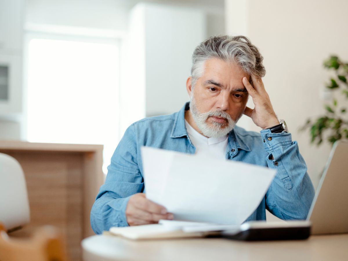 Uomo che legge un foglio ed รจ preoccupato