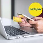 PC e un uomo con lo smartophone e carta gialla Postepay