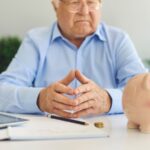 Uomo che pensa davanti ad un foglio e una penna