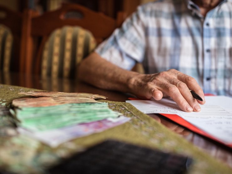 Uomo che scrive e soldi in euro sul tavolo