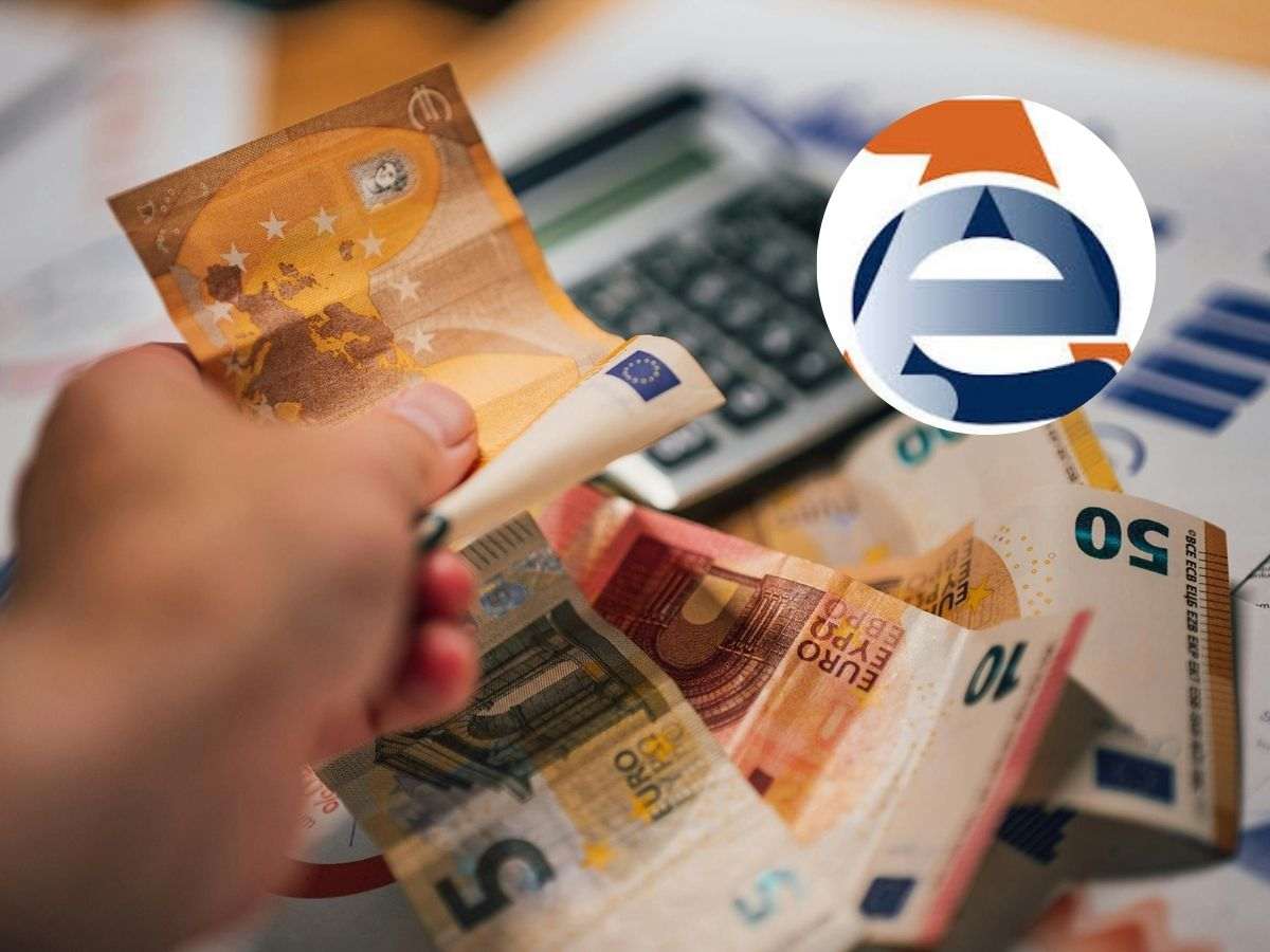 Mano che contano i soldi e calcolatrice con logo Agenzia delle Entrate