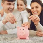 Famiglia che inserisce monete nel salvadanaio