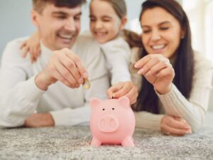 Famiglia che inserisce monete nel salvadanaio