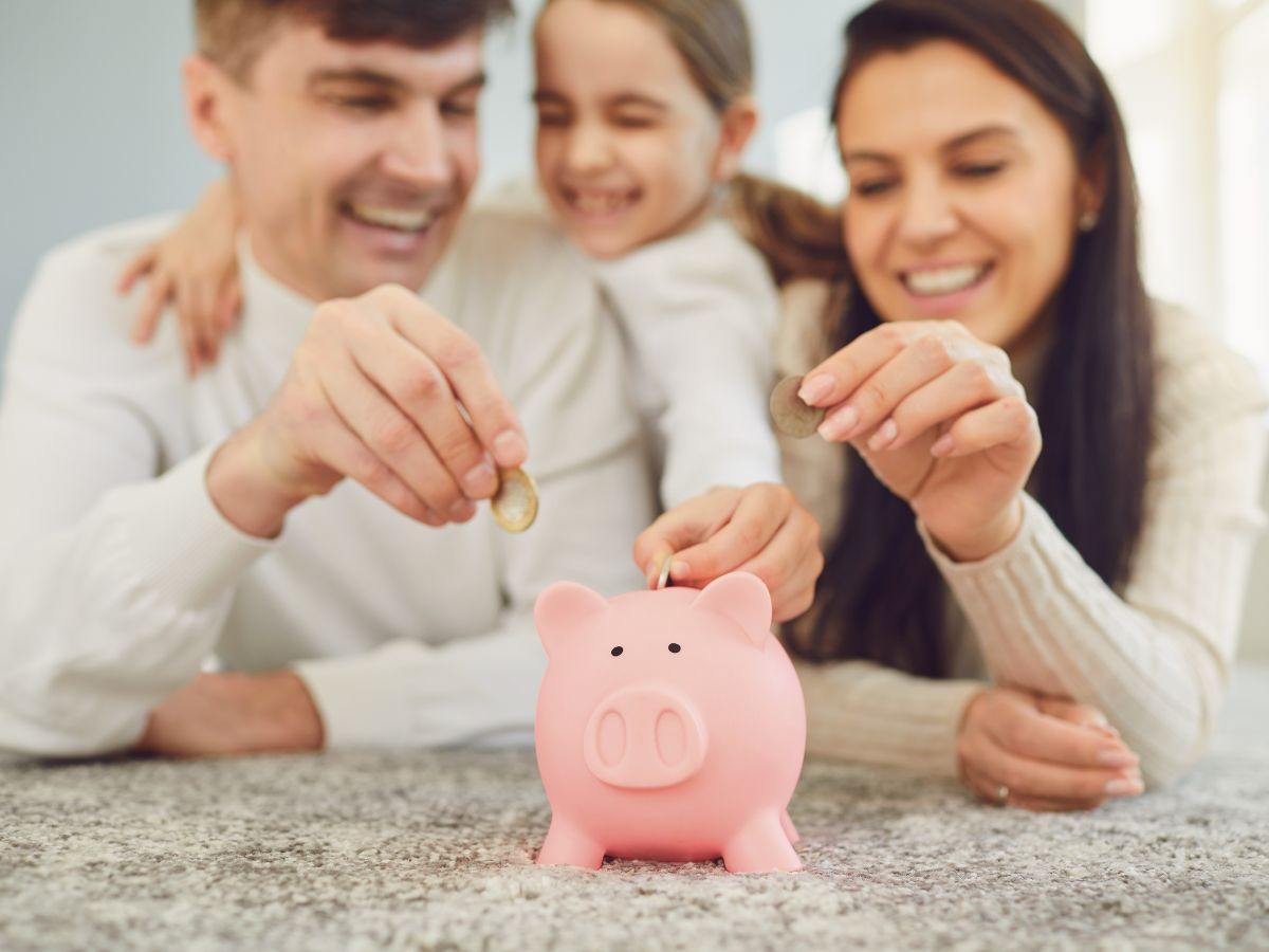 Famiglia che inserisce monete nel salvadanaio