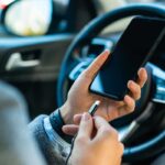 Persona carica il telefono in auto