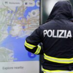 Poliziotta di spalle, sullo sfondo smartphone con aperto Google Maps